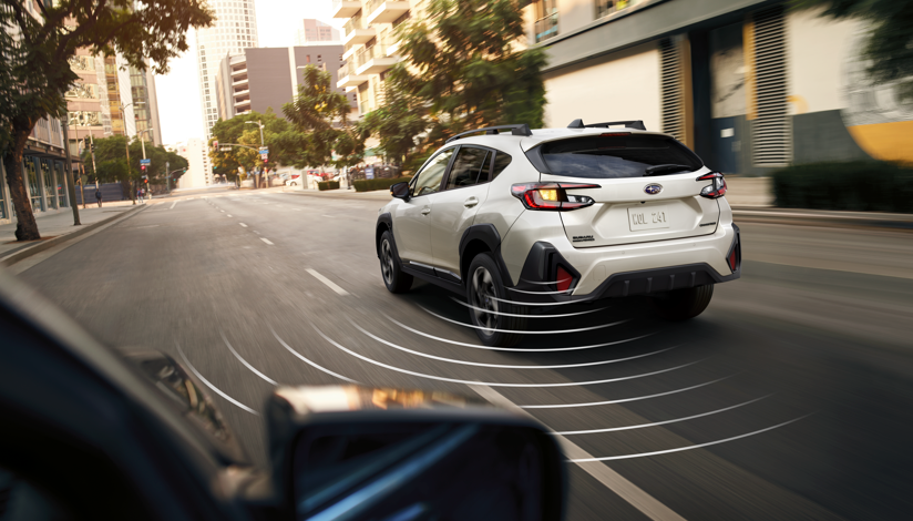 2026 Subaru Crosstrek driving in city traffic with blind-spot detection system active