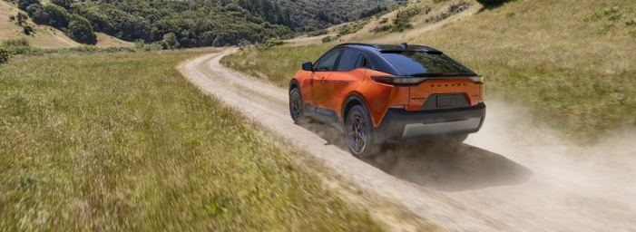 Rear exterior action beauty major of the 2026 Uncharted driving along a graveldirt road with dust kicked up behind it.