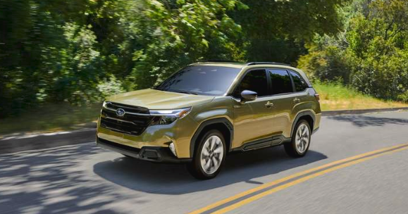 Forester Hybrid - Exterior front 3/4 action major of the Forester Hybrid in Autumn Green Metallic driving on a paved road.
