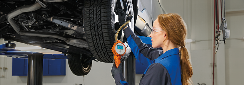 A Subaru technician checking tire pressure. | All American Subaru of Old Bridge in Old Bridge NJ