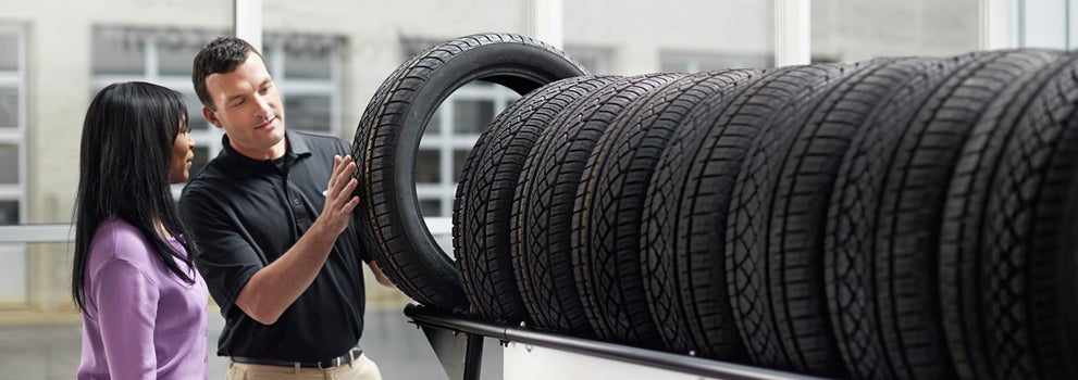 Subaru service representative showing customer a tire. | All American Subaru of Old Bridge in Old Bridge NJ