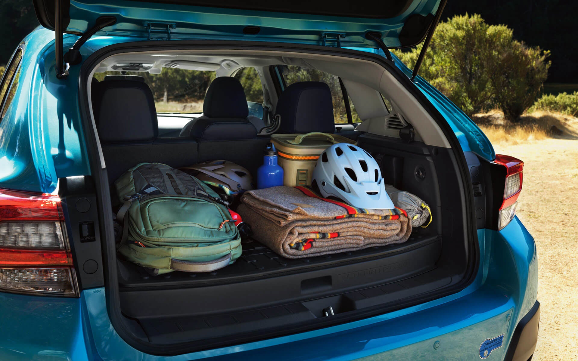 A backpack, blanket, and bike helmet in the rear cargo area of a Crosstrek Hybrid | All American Subaru of Old Bridge in Old Bridge NJ