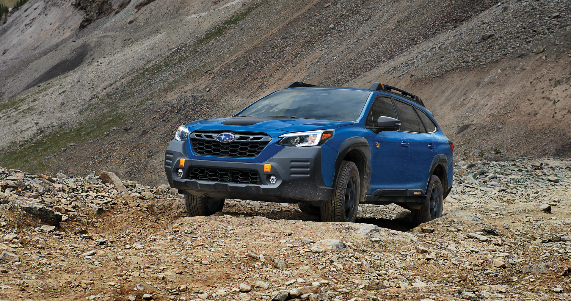 A 2023 Outback Wilderness driving on a trail in the mountains. | All American Subaru of Old Bridge in Old Bridge NJ
