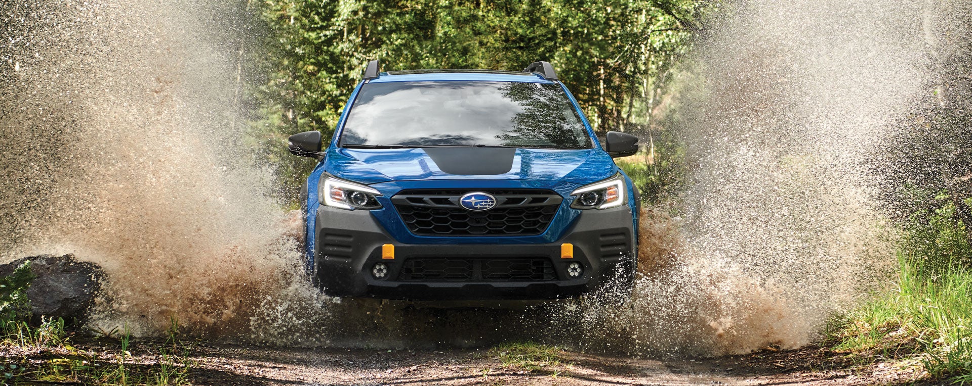 A 2023 Outback Wilderness driving on a muddy trail. | All American Subaru of Old Bridge in Old Bridge NJ